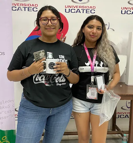 Dos asistentes con tazas del evento